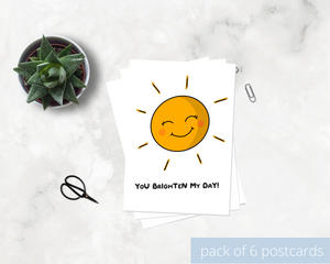 Poppleberry A6 positivity postcard, with a smiling orange sunshine illustration and uplifting message, on white cardstock.