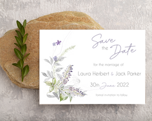 Muted lavender & greenery Poppleberry A6 wedding save the date card, laid on a stone.