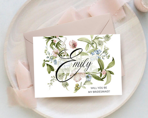 Front of a spring floral A6 Poppleberry 'Will you be my...?' bridesmaid proposal card with personalised name and blush envelope.
