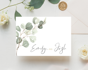 Close-up of a green eucalyptus A6 Poppleberry accordion fold all-in-one wedding invitation, folded with a wax seal