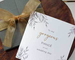 Front of a Poppleberry square luxury charcoal-design wedding day card, with matching presentation box and gold organza ribbon tie.