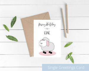 Poppleberry A6 folded birthday card, with a smiling white sheep illustration, on white cardstock and kraft brown envelope.
