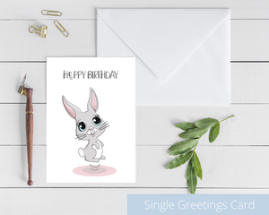 Poppleberry A6 folded birthday card, with a smiling grey bunny illustration, on white cardstock and white envelope.