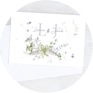 Close-up of a lavender & greenery A6 Poppleberry accordion fold all-in-one wedding invitation, with white envelope.