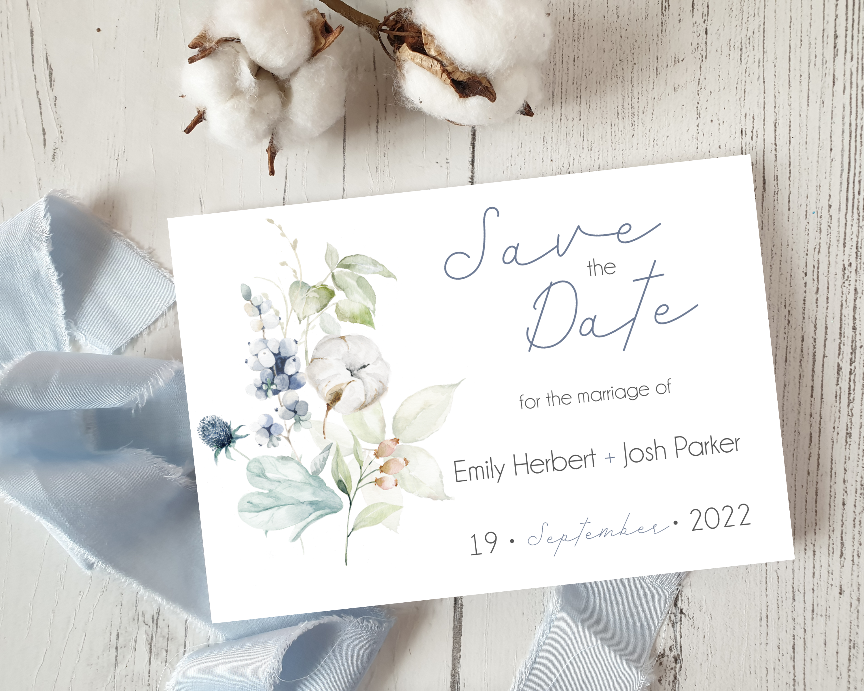 Dusty blue & cotton flowers Poppleberry A6 wedding save the date card, with cotton tufts and matching ribbon in background.