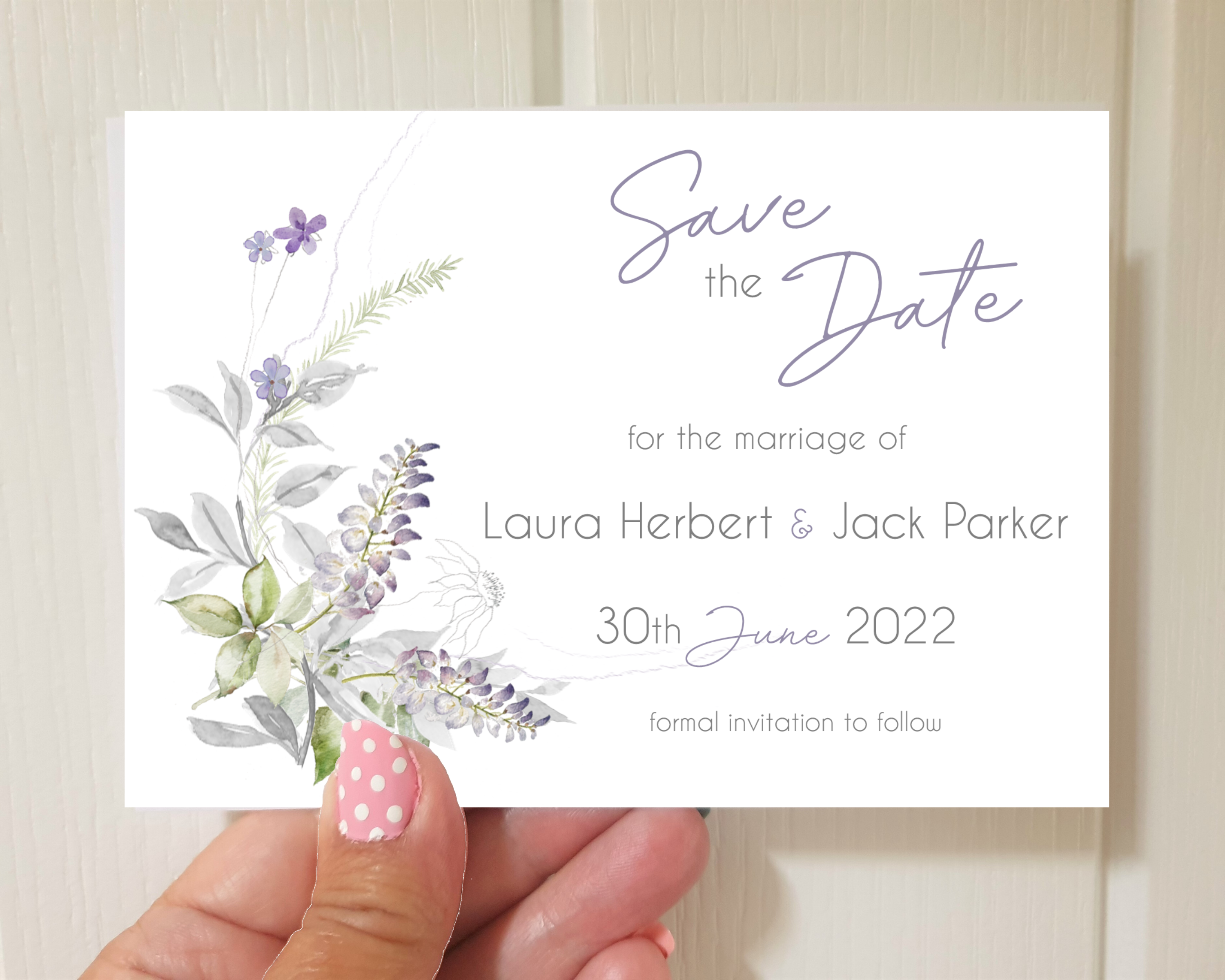 Muted lavender & greenery Poppleberry A6 wedding save the date card, held to show size.