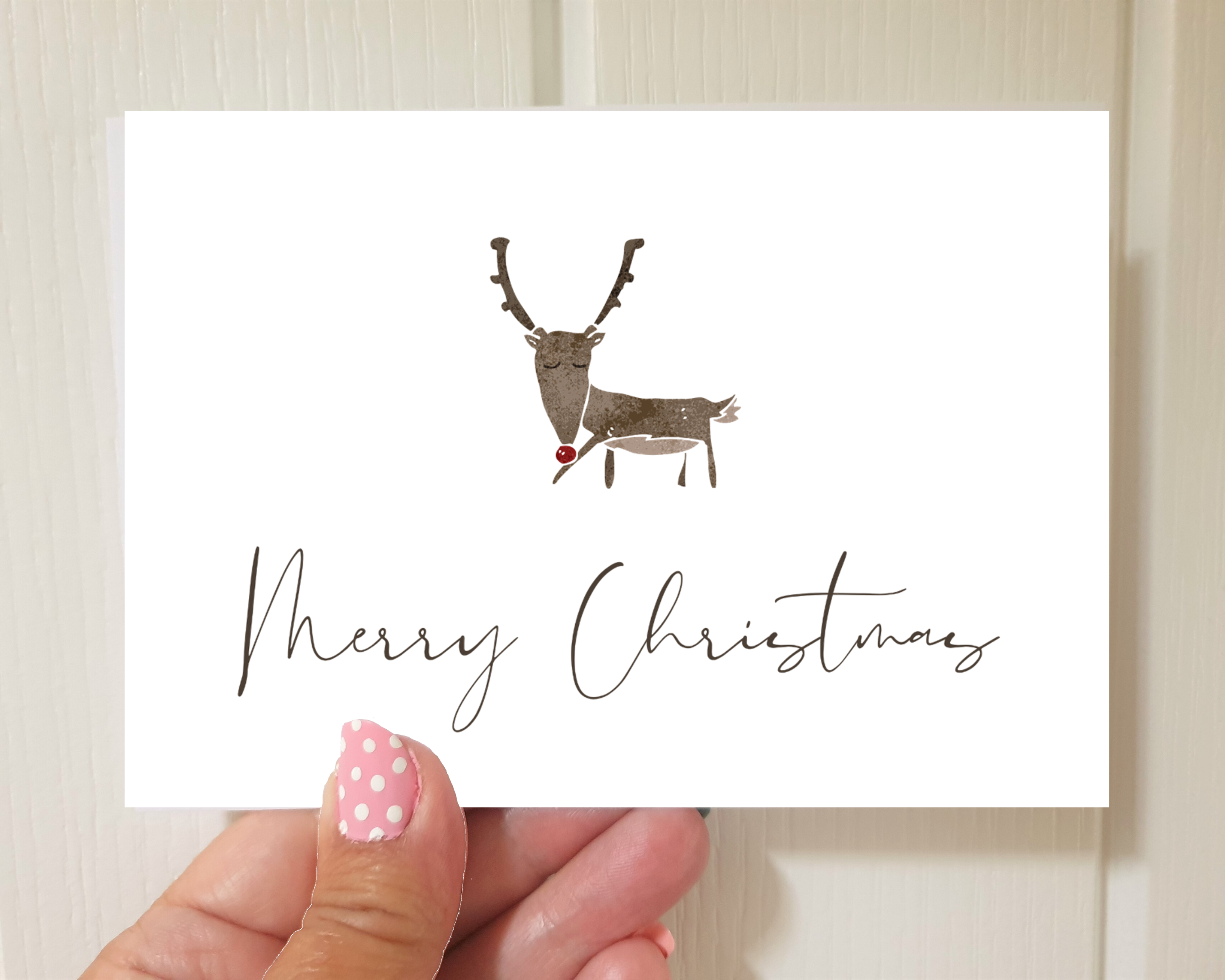 Poppleberry A6 Watercolour Reindeer Illustration Christmas Cards on White Cardstock, size compared to thumb.