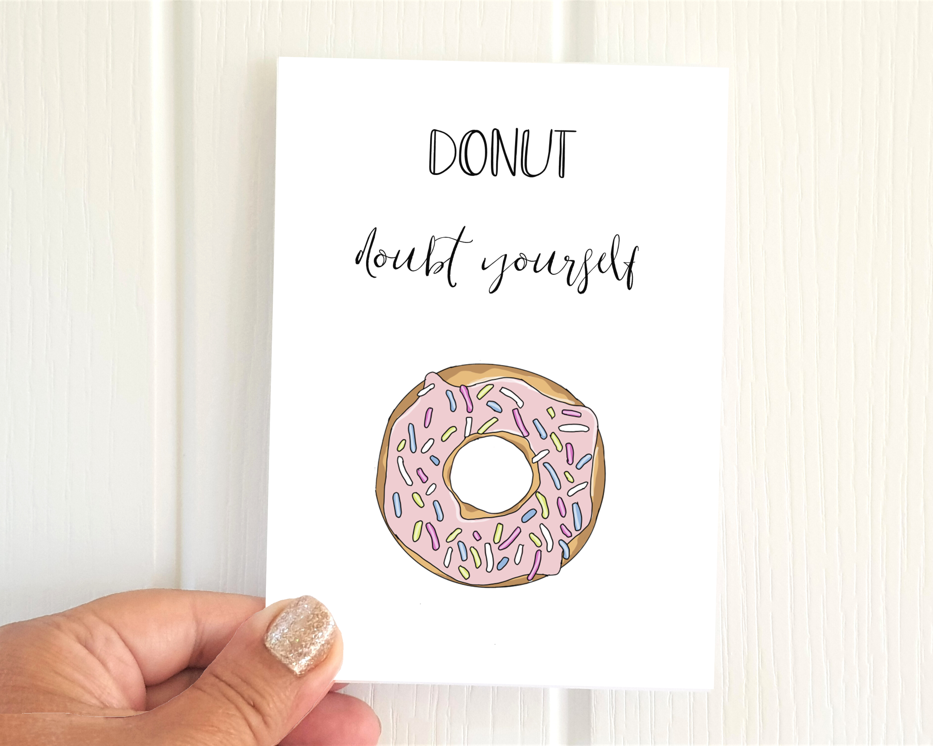 Poppleberry A6 ''Donut' Doubt Yourself' positivity postcard, with a pink donut illustration & pun, on white cardstock.