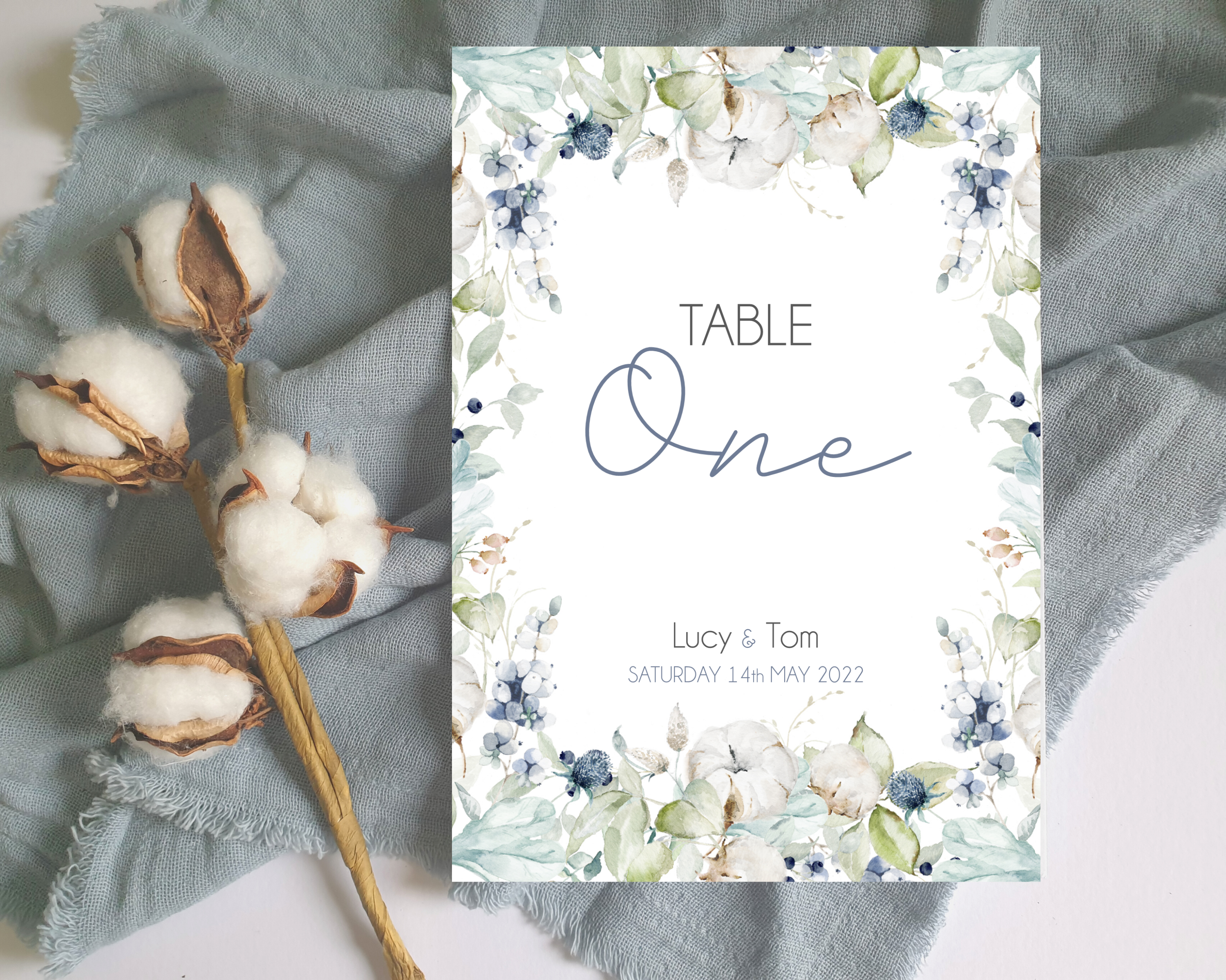 A Poppleberry dusty blue & cotton flowers wedding table number card, for 'Table One' of Lucy & Tom's wedding, in A5 size.